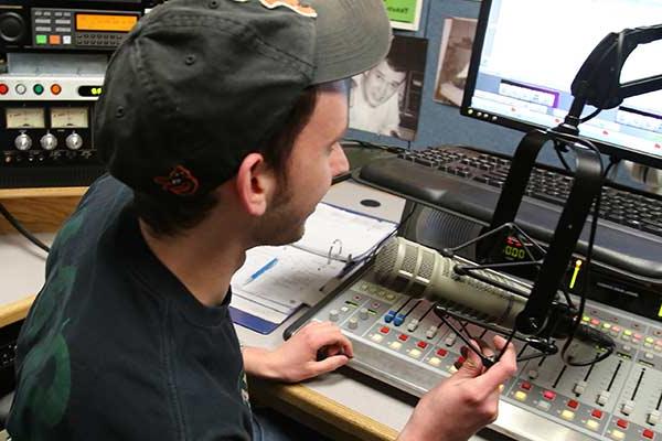 Keystone College DJ works in soundbooth.